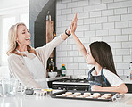 High five, kid and baking with mom for development, bonding and teaching of skills to bake in the kitchen. Cooking, cook and motivation of mother and daughter in the family home for culinary skills