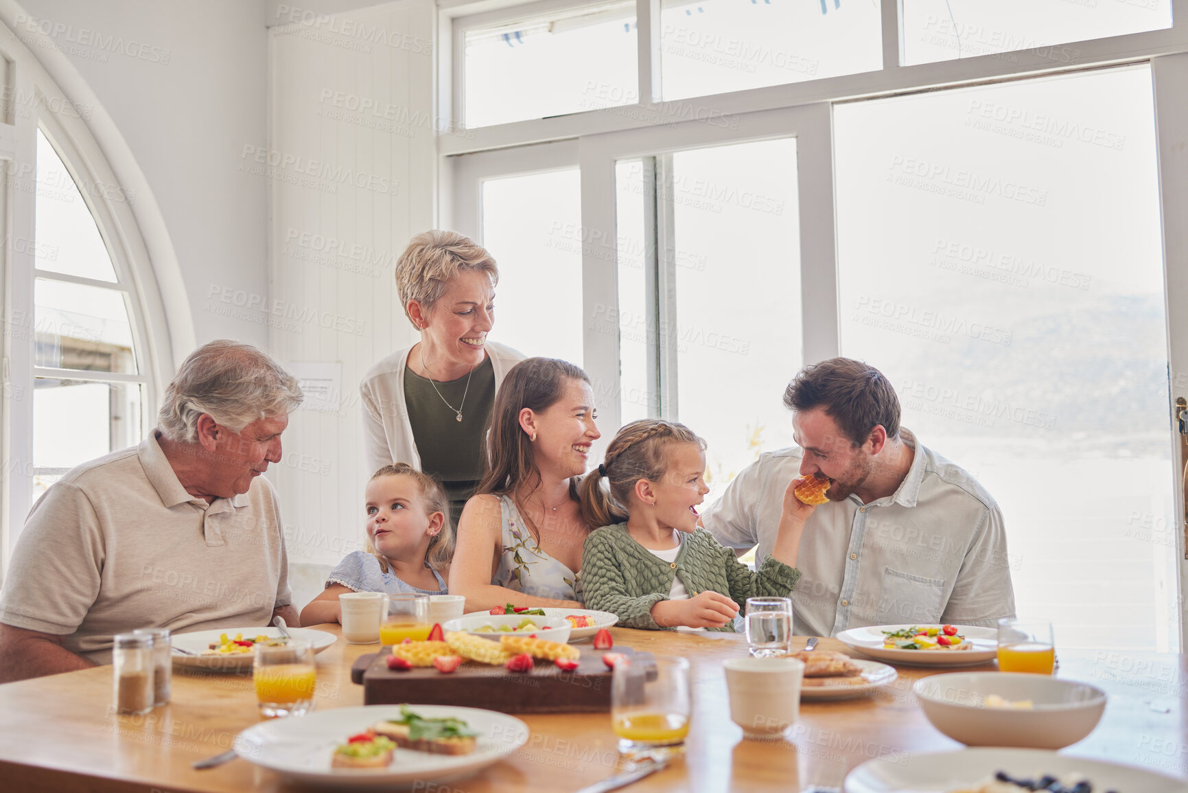 Buy stock photo Parents, kids and grandparents at breakfast, happy and eating together on holiday, bonding and food in family home. Men, women and girl children with fruits, waffles and diet choice in dining room