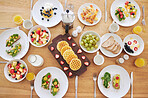 Table, breakfast and health with food, fruits and bread in home with plate, cutlery or salad. Above countertop, container or diet for nutrition with waffles, toast or juice for eating, drink and milk