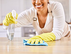 Happy woman, spray bottle and hands cleaning table in housekeeping, hygiene or disinfection in kitchen. Closeup of female person gloves wiping surface counter or furniture in bacteria or germ removal