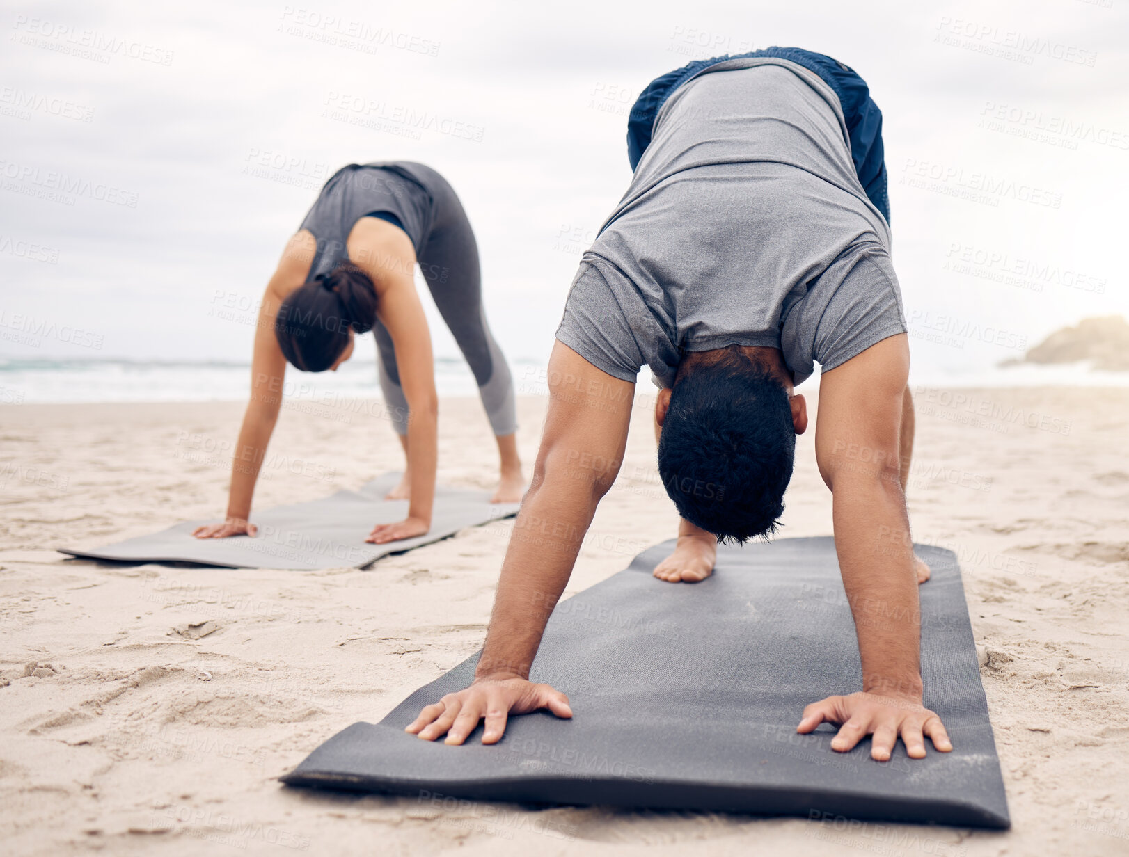 Buy stock photo Yoga, fitness and wellness with a couple on the beach for a mental health or awareness workout in the morning. Exercise, pilates or mindfulness with a young man and woman by the ocean or sea for zen