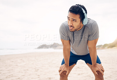 Buy stock photo Man, headphones and break from fitness, beach and exhausted at sea, rest and relaxing for health. Male person, wellness and music for cardio, workout and tired from training, streaming radio or song
