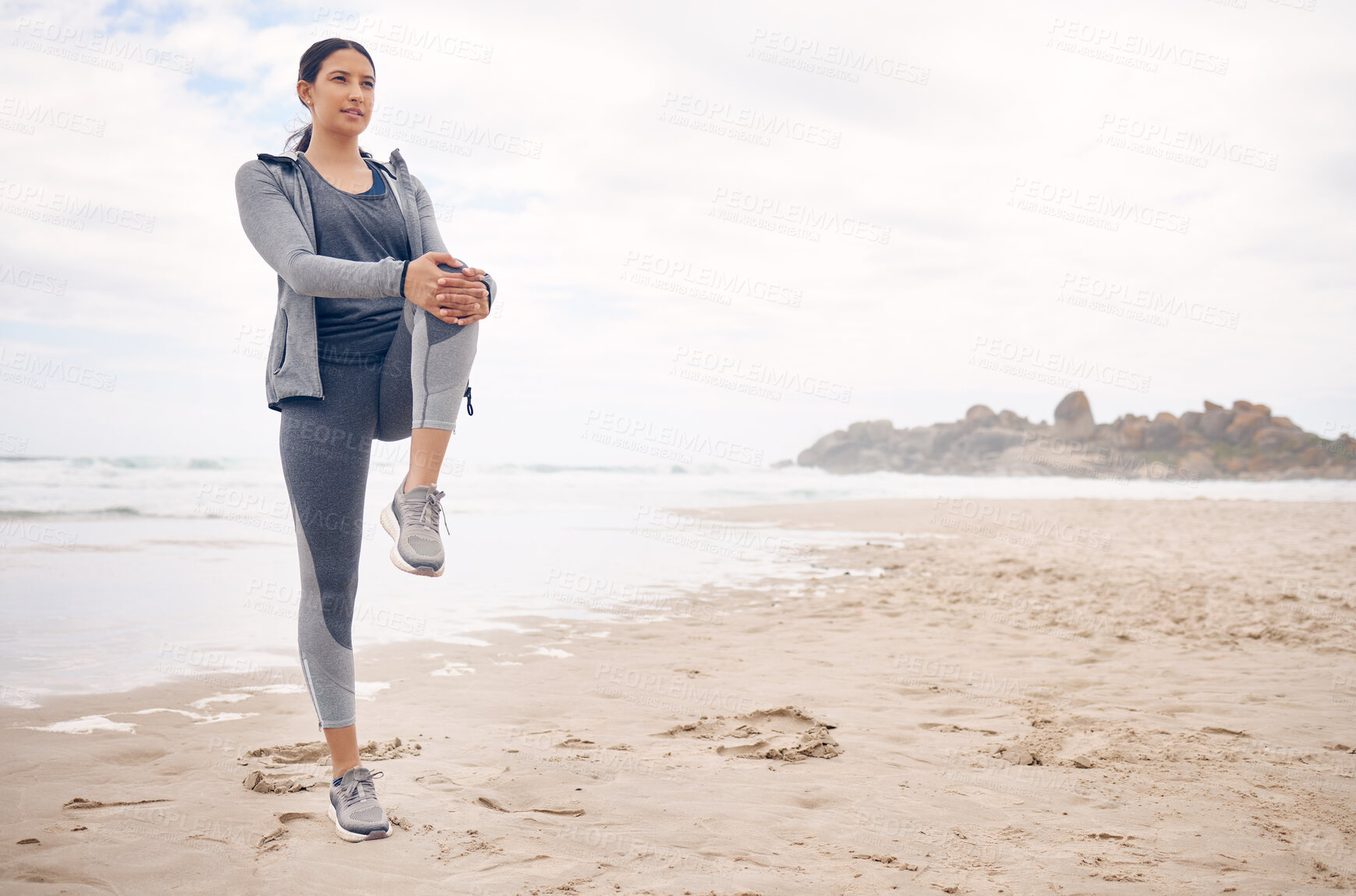 Buy stock photo Fitness, warm up and woman athlete on the beach for health and race, marathon or competition training. Sports, workout and young female runner stretching for cardio exercise by the ocean or sea.