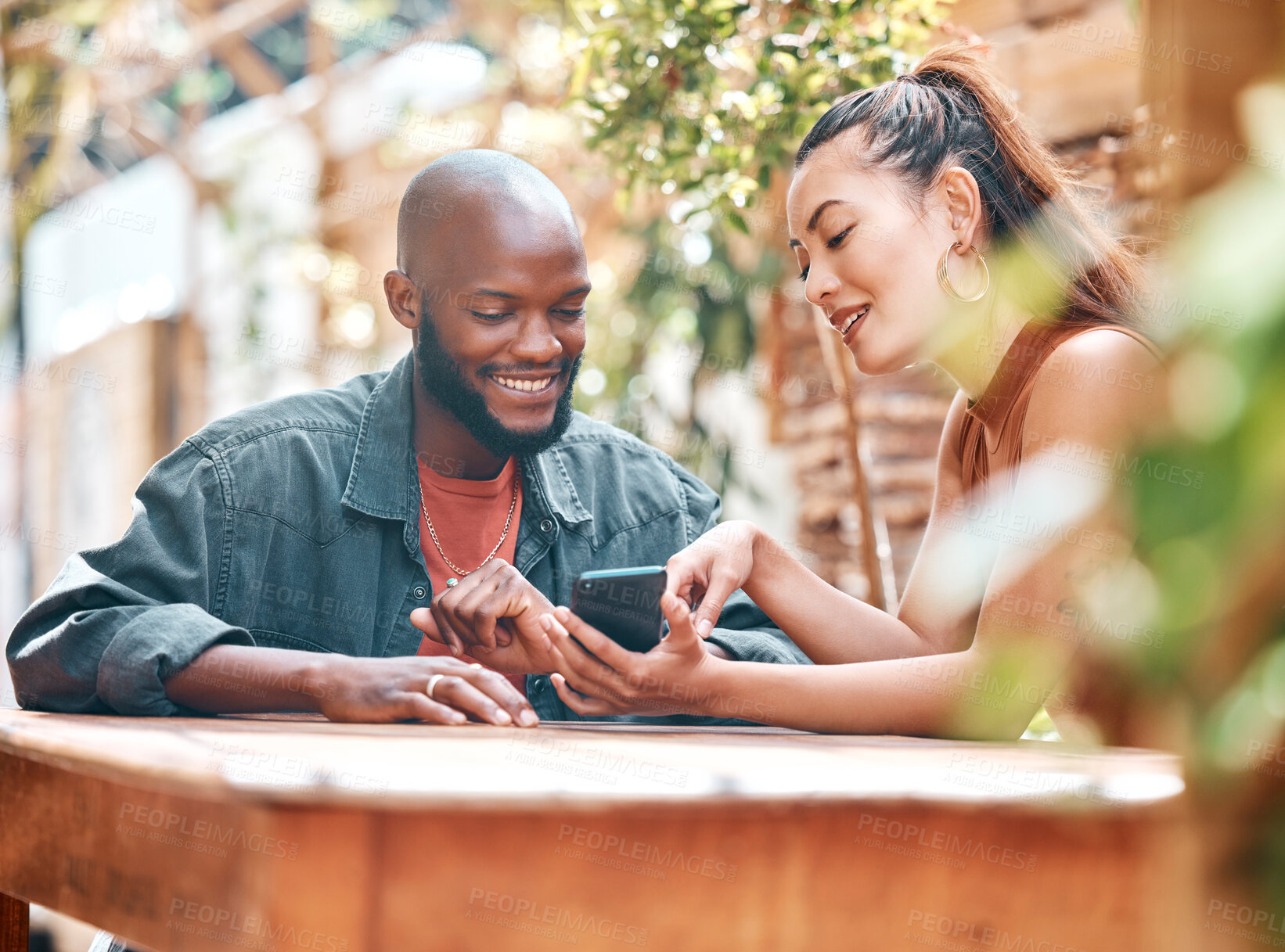 Buy stock photo Man, woman and showing of phone at cafe, restaurant or bistro with announcement on social media. Interracial couple, people or friends with mobile app with notification, alert or promotion on website