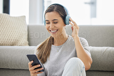 Buy stock photo Happy, headphones and phone with woman at home with remote work, music and living room with smile. Podcast, tech and internet with radio streaming and audio with mobile by a sofa with digital job