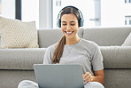 Happy, headphones and laptop with woman online in home with remote work, music and living room with smile. Podcast, tech and internet with radio streaming and audio with computer by a sofa with job