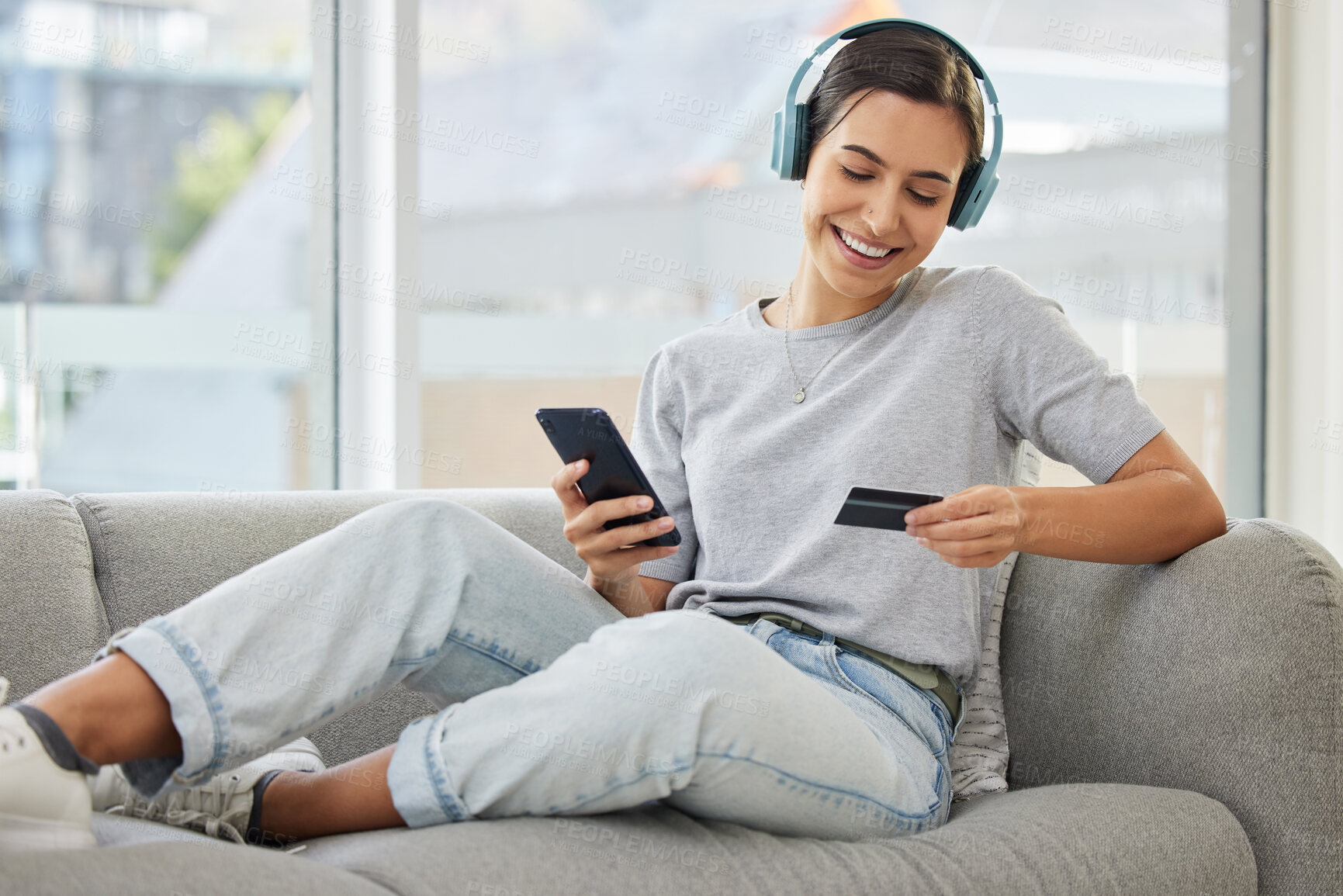 Buy stock photo Sofa, headphones and phone with credit card and woman at home with purchase, music and smile. Online shopping, tech and internet with banking and audio with mobile by a sofa with digital buying