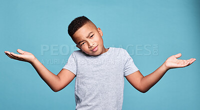 Buy stock photo Children, confused and shrug with a boy kid in studio on a blue background looking bored or clueless. Question, doubt and kids with a male child shrugging his shoulders with an uncertain expression