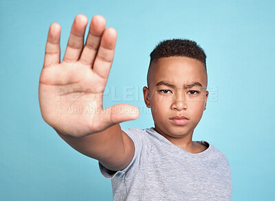 Buy stock photo Hand, stop and children with a boy in studio on a blue background against bullying, abuse or violence. Kids, human rights and empowerment with a young male child taking a stand for our youth