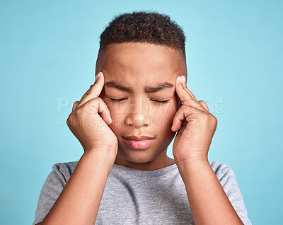 Buy stock photo Child with headache, stress and mental health problem or fatigue pain on blue studio background. Frustrated african american kid, depressed boy and angry youth with fingers massaging temples of head