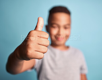 Buy stock photo Hand, thumbs up motivation with a winner kid saying yes or thank you in studio on a blue background. Children, winning and achievement with a boy child in celebration of success, a goal or target