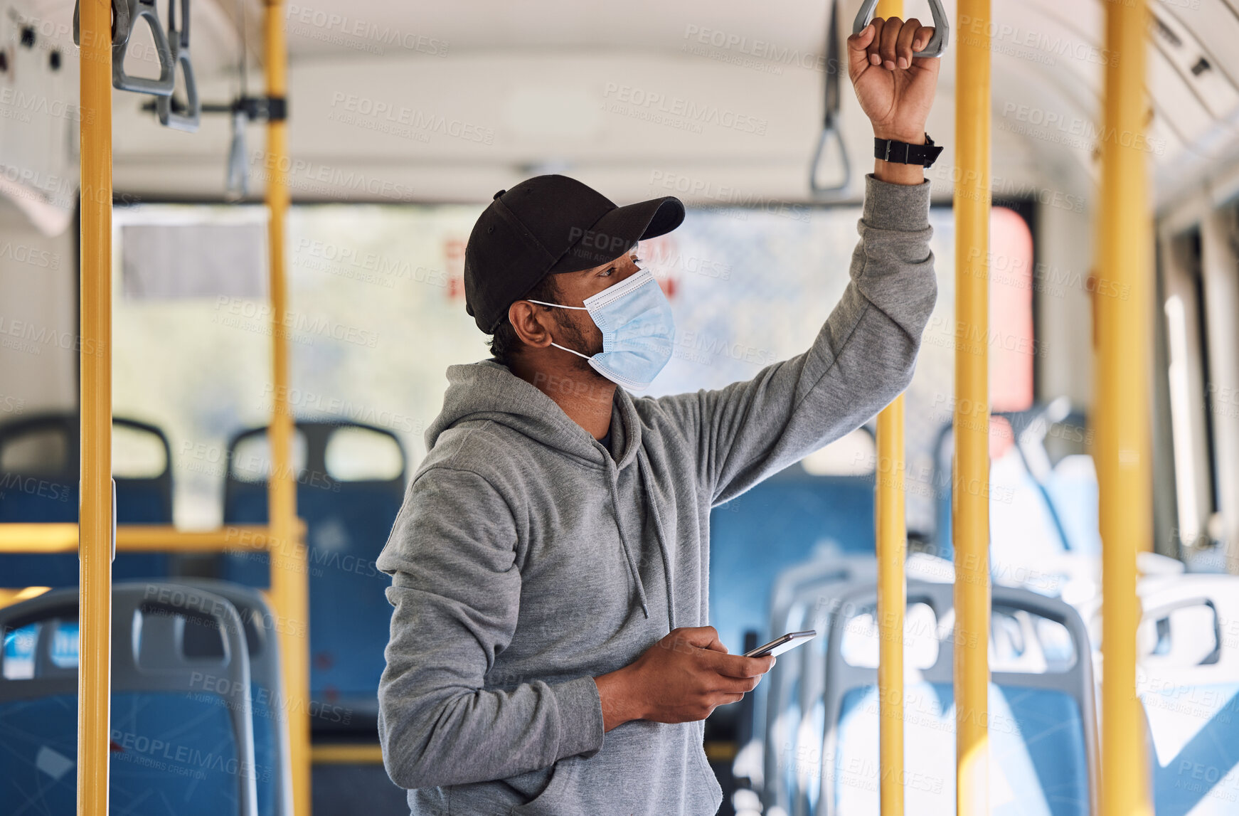 Buy stock photo Man in bus with mask, phone and commute to city in morning, checking service schedule or social media. Public transport safety in covid, urban travel and person in standing with smartphone connection