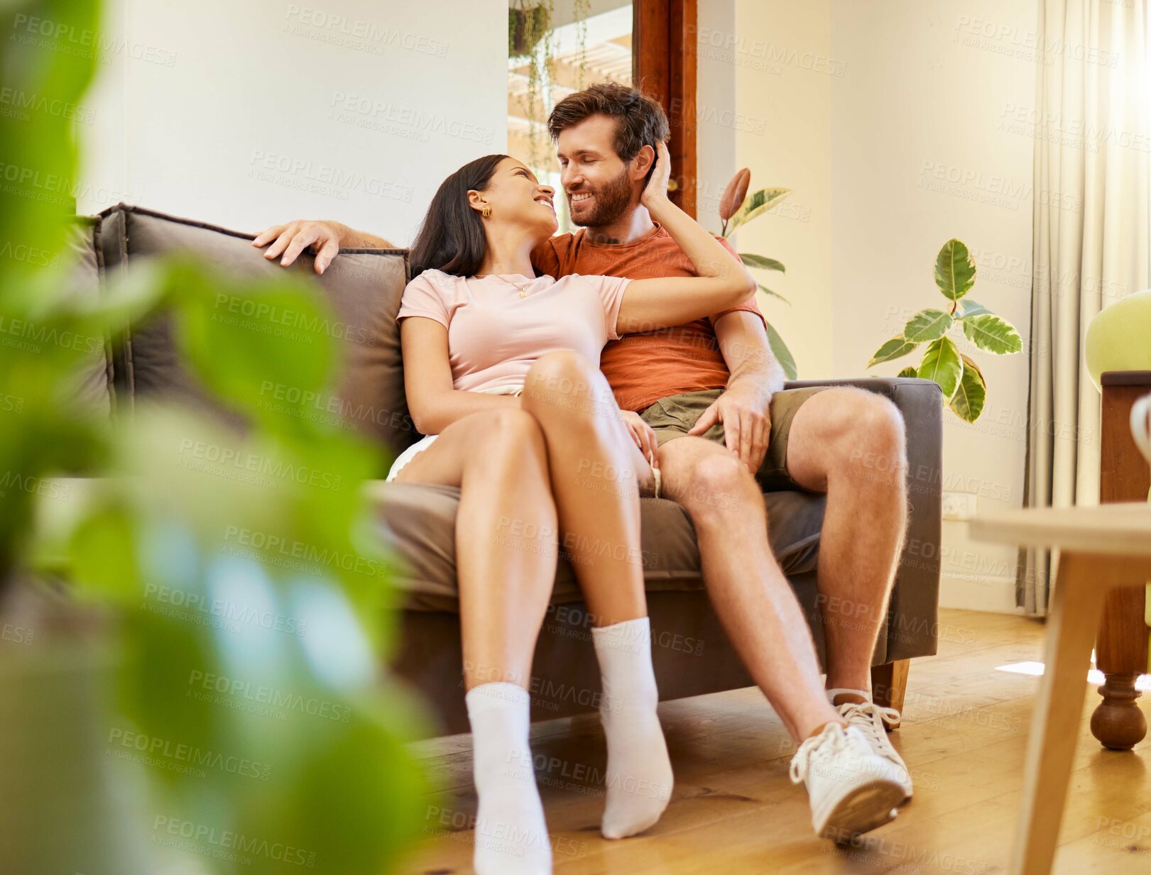 Buy stock photo Happy, romance and couple relax indoors together, bonding and talking on sofa together. Young husband and wife sharing intimate moment, enjoying conversation, relationship and freedom at home