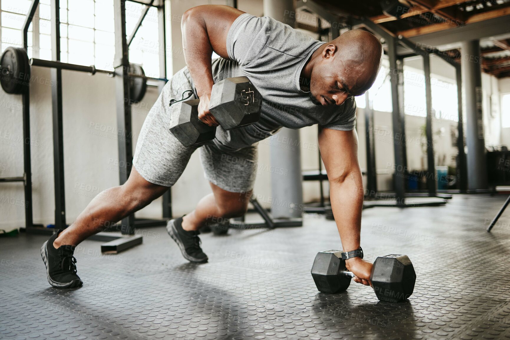 Buy stock photo Dumbbell, fitness and bodybuilder black man with workout training in gym or garage studio for wellness, body goal and motivation. Power, strong and african sports man doing push up exercise with gear