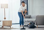 Woman, vacuum machine and cleaning the floor in the living room in home. Happy latino cleaner doing housework, housekeeper or job in a clean lounge, hotel room or house while alone spring cleaning
