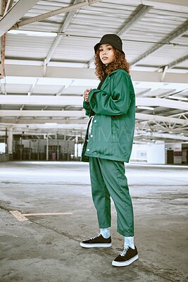 Buy stock photo Portrait, fashion or stylish young gen z woman stand in a warehouse with green clothing. Trendy, hipster latino girl with attitude and curly hair in industrial building or factory with pride or cool
