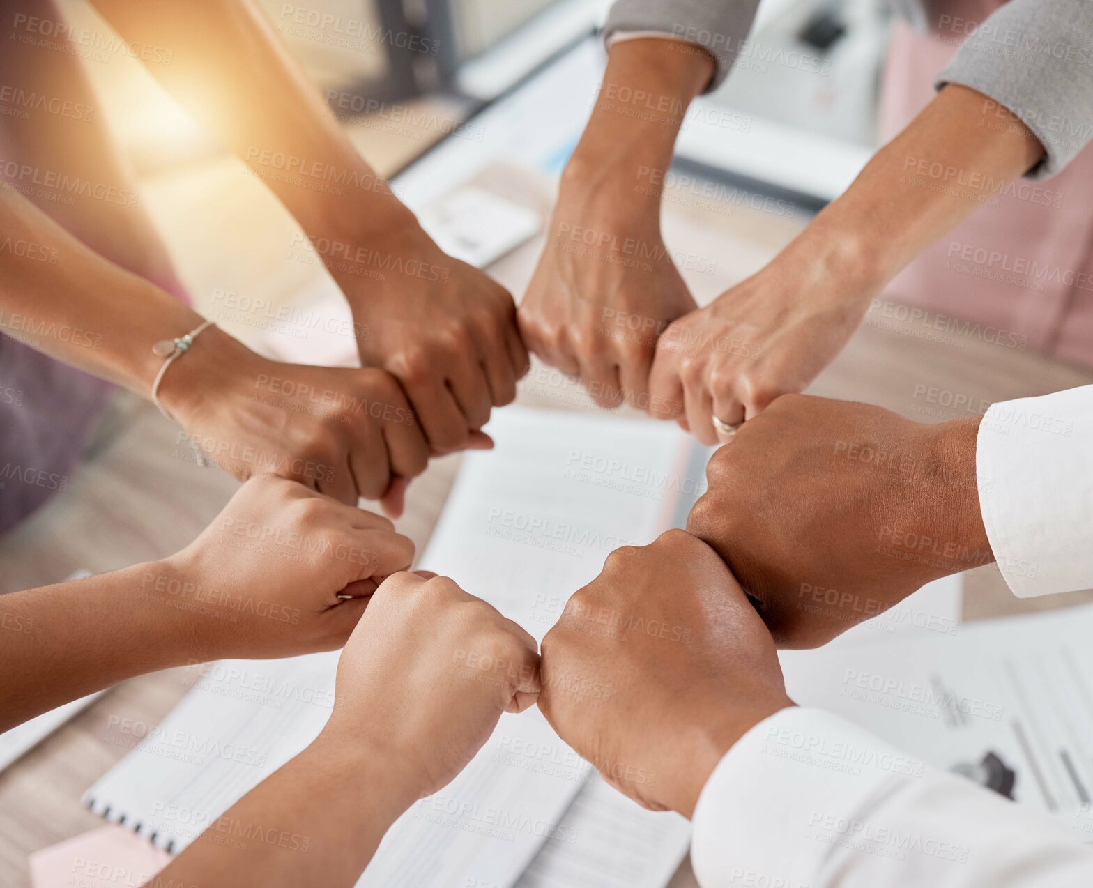 Buy stock photo Teamwork, support and circle of hands in fist of business people in meeting with documents. Diversity, collaboration and aerial of workers fists for motivation, community and growth in workplace