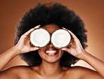 Coconut oil, black woman and beauty for natural cosmetics, healthy lifestyle and facial skincare on studio background. Happy african model cover eyes with tropical summer fruit for wellness nutrition