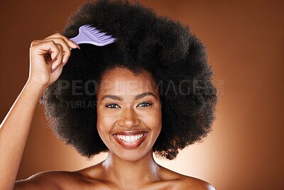 Buy stock photo Hair care, beauty and black woman with comb in afro smiling in studio on brown background. Fashion, hair salon and face portrait of girl brushing natural, curly and healthy hair with organic products