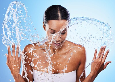 Buy stock photo Water splash, skincare and woman cleaning face in studio isolated on blue background. Health, wellness or hygiene of female model from India washing and bathing for beauty, body care and healthy skin
