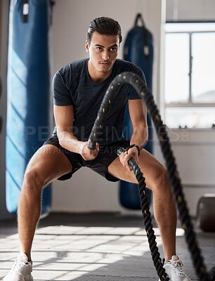 Buy stock photo Fitness, man and rope exercise, training and workout, muscle, energy and wellness in sports gym. Young body builder guy swinging battle ropes with energy, speed and power, challenge and performance 