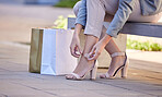 Fashion, city and woman tie heels after shopping in retail boutique store. Shopping bag, discount deals or female in street with luxury designer high heels or shoes after sale in mall, plaza or shop