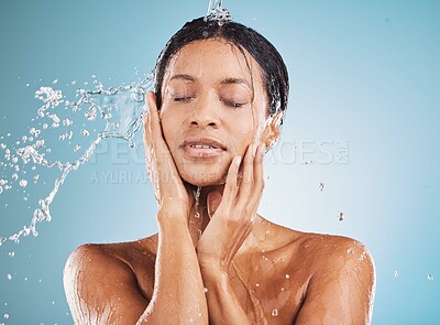 Buy stock photo Water, cleaning and shower with a black woman in studio on a blue background for hygiene or hydration. Relax, skincare and wellness with an attractive young female washing her skin in the bathroom
