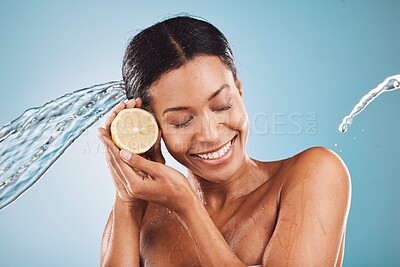 Buy stock photo Water splash, skincare and face of woman with lemon in studio isolated on blue background. Hygiene, cleaning or female with eyes closed holding fruit for nutrition, wellness or healthy vitamin c diet