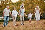 Happy family, holding hands or walking with children in park for summer holiday, vacation break or bonding activity. Smile, happy kids or mother, father or senior retirement elderly in nature garden