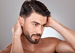 Face, beauty and a man with clean, glow and healthy skin on a grey studio background for skincare, dermatology and hygiene. Headshot of a male with a barber haircut and cosmetics for self care