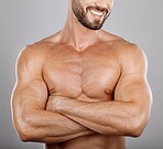 Muscles, man and with arms crossed, healthy lifestyle and bodybuilding on grey studio background. Exercise, male bodybuilder and athlete with confidence, chest and wellness for body care and luxury