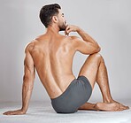 Fitness man, body muscles and back on studio background for bodybuilding, workout training goals or exercise wellness. Underwear model, bodybuilder and strong person on gray backdrop for healthcare