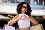 Heart, portrait and woman with love for shopping, retail support and smile for fashion discount in the city of Miami. Happy, emoji and girl with hand sign in the street for a shopping bag sale