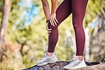 Knee injury, woman runner and nature park path for fitness, health or rest by trees to massage legs. Outdoor training, running and relax in woods for joint pain emergency, anatomy problem or workout