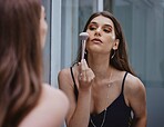 Woman with makeup brush, cosmetic application in mirror and getting ready at home in Los Angeles. Apply luxury beauty product in reflection, face of gen z model and creative aesthetic on skin