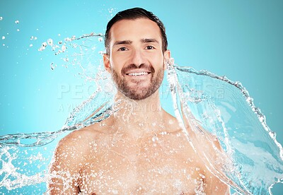 Buy stock photo Water splash, skincare and portrait of man with smile on face and morning clean routine isolated on blue background. Hygiene, happy male model and grooming for health, wellness and beauty in studio.