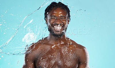 Buy stock photo Water splash, beauty and black man isolated on blue background for face cleaning, body shower and skincare. Strong, muscle and happy model or person facial glow in studio headshot washing or hygiene