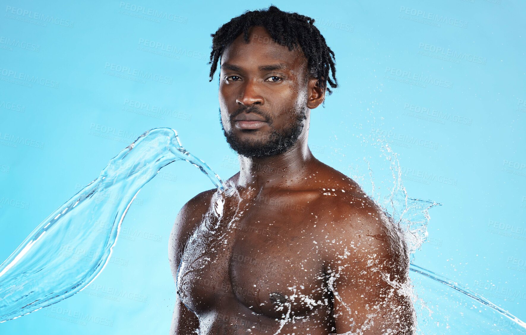 Buy stock photo Skincare, shower and portrait of a black man with a water splash isolated on a blue background. Cleaning, beauty and African model for grooming, hygiene and care of body on a studio backdrop