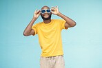 Sunglasses, black man and fashion on a blue background with cool and trendy style with mock up space. Young model person with eyewear in studio for advertising designer brand, logo or color in hands