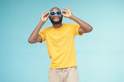 Buy stock photo Sunglasses, black man and fashion on a blue background with cool and trendy style with mock up space. Young model person with eyewear in studio for advertising designer brand, logo or color in hands