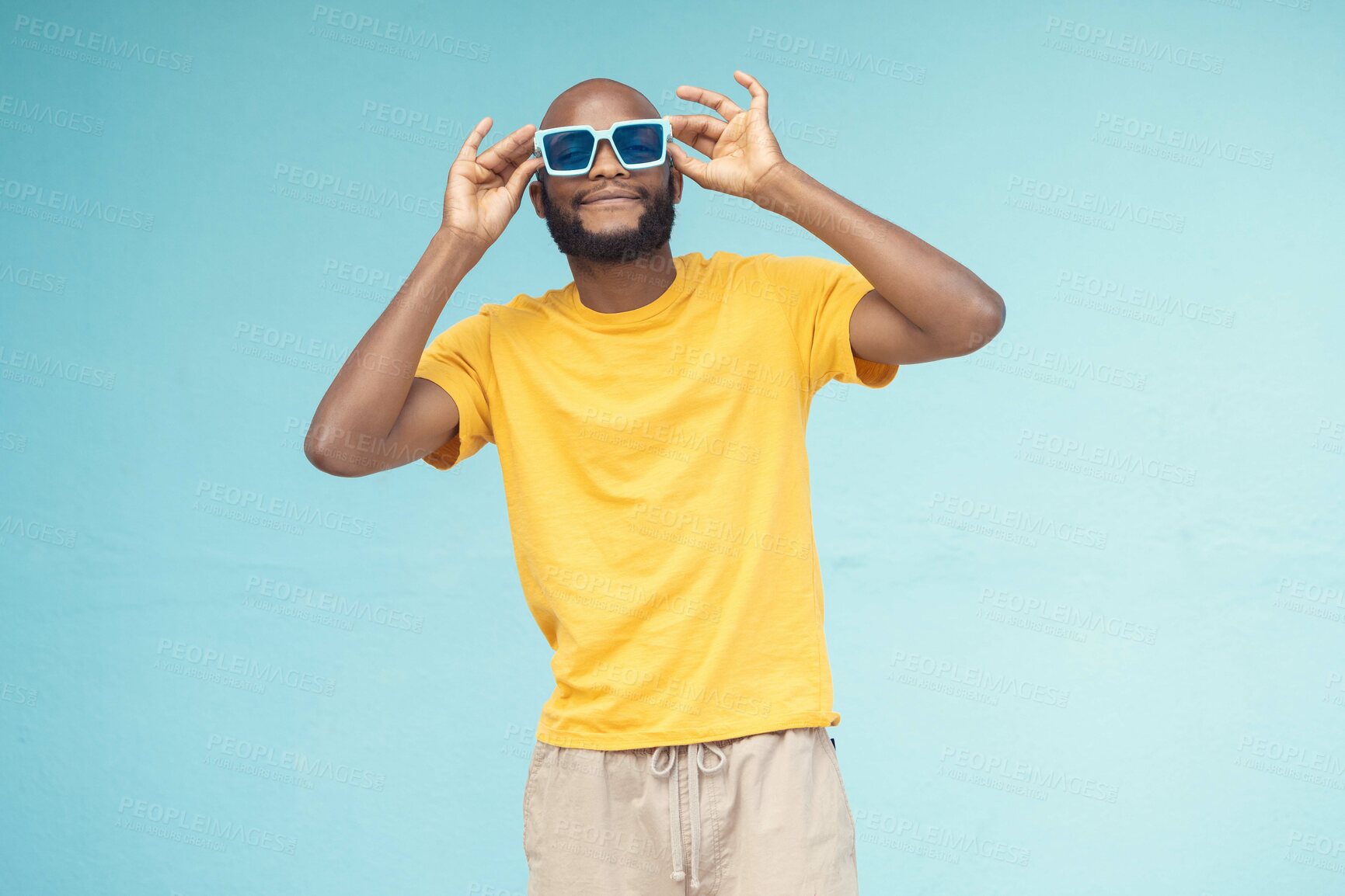 Buy stock photo Sunglasses, black man and fashion on a blue background with cool and trendy style with mock up space. Young model person with eyewear in studio for advertising designer brand, logo or color in hands