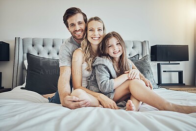 Buy stock photo Love, relax and portrait of a family on a bed embracing, bonding and resting together at their home. Happiness, mother and father sitting and relaxing with their girl child in their bedroom in house.