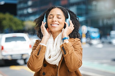 Buy stock photo Black woman with headphones for listening to music in city for travel, motivation and happy mindset. Young person on an urban street with buildings background while streaming podcast or audio outdoor