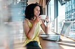 Window, laptop and coffee shop with a black woman blogger drinking a beverage during remote work. Internet cafe, freelance and startup with an attractive young female working in a restaurant