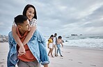 Happy, piggyback or couple of friends at a beach on a relaxing holiday vacation bonding in nature together. Love, man and Asian woman with smile at sea enjoys traveling on ocean trips in Miami, USA