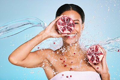 Buy stock photo Pomegranate, skincare and woman portrait with beauty and healthy skin or diet on blue background. Face of aesthetic model person with water splash and fruit for sustainable facial health and wellness