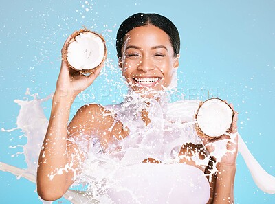 Buy stock photo Beauty, skin care and woman with coconut for healthy skin and diet on a blue background. Face of happy aesthetic model person with milk splash and fruit for sustainable facial health and wellness