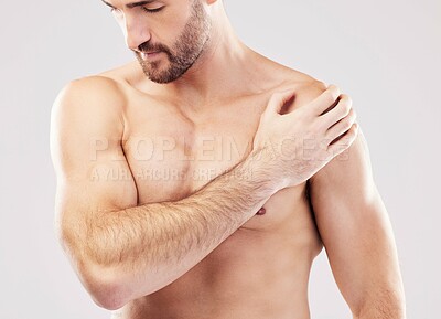 Injury, feeling and man with arm pain after sports isolated on a grey studio background. Fitness, accident and person touching a shoulder with a broken bone, body strain and problem after workout