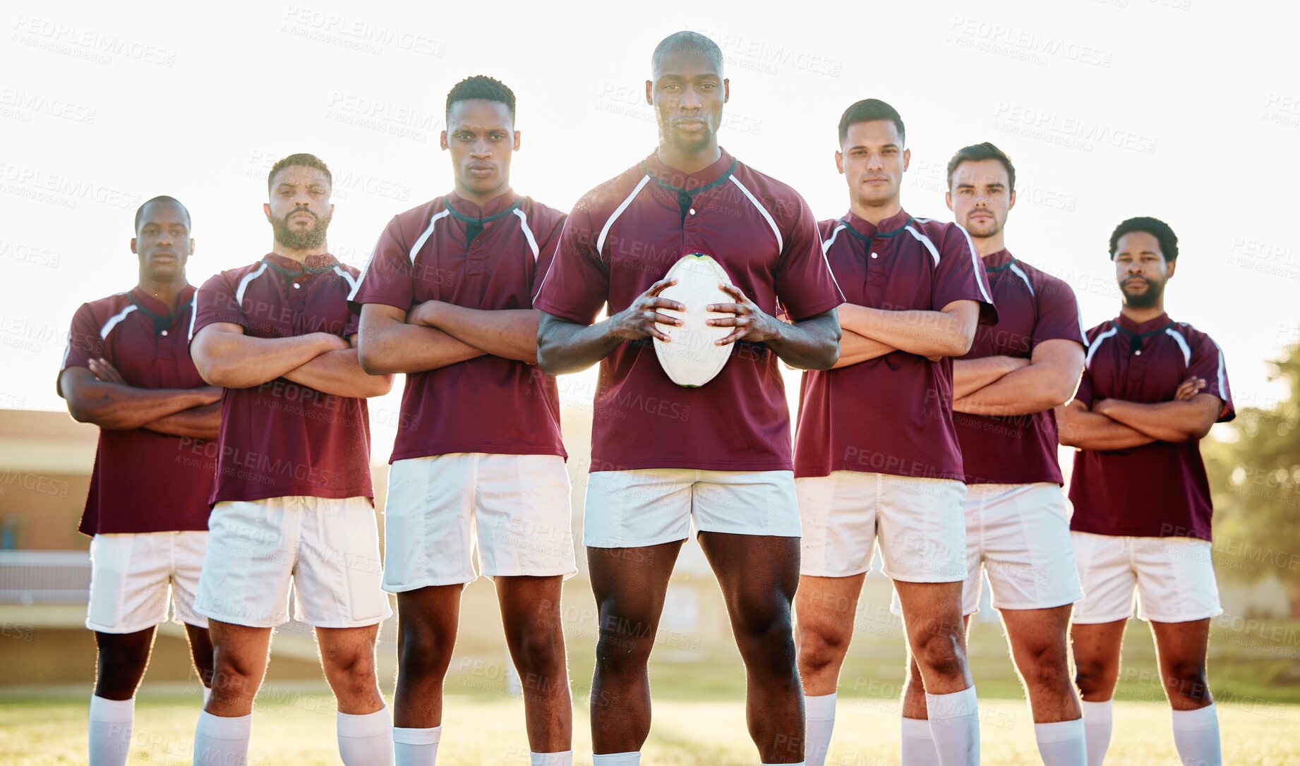 Buy stock photo Rugby, black man with ball and team portrait on field, solidarity and confidence for winning game. Diversity, leadership and teamwork, group of strong sport people standing together in power on field