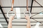 Hands, rings and gymnastics in fitness for workout, strength training or practice at gym. Hand of athlete, gymnast or acrobat holding or hanging on ring circles for strong intense pull up exercise